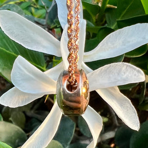 Side view of round Hawaiian flower pendant 